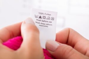 A close-up of a clothing care label with various laundry care symbols on it.