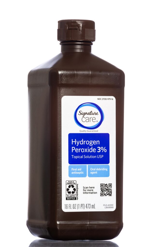 A brown bottle of hydrogen peroxide standing upright against a white background