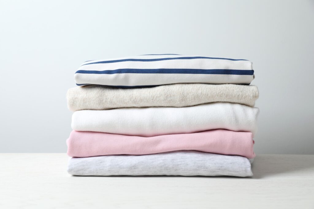 Stacks of freshly laundered, neatly folded clothes on a table