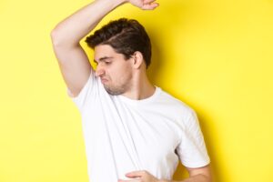 man-smelling-underarm-white-tshirt.
