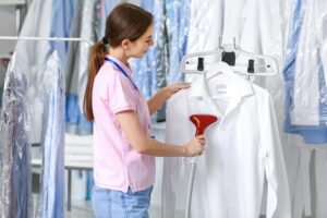 Suits and jackets hanging in plastic dry cleaning covers