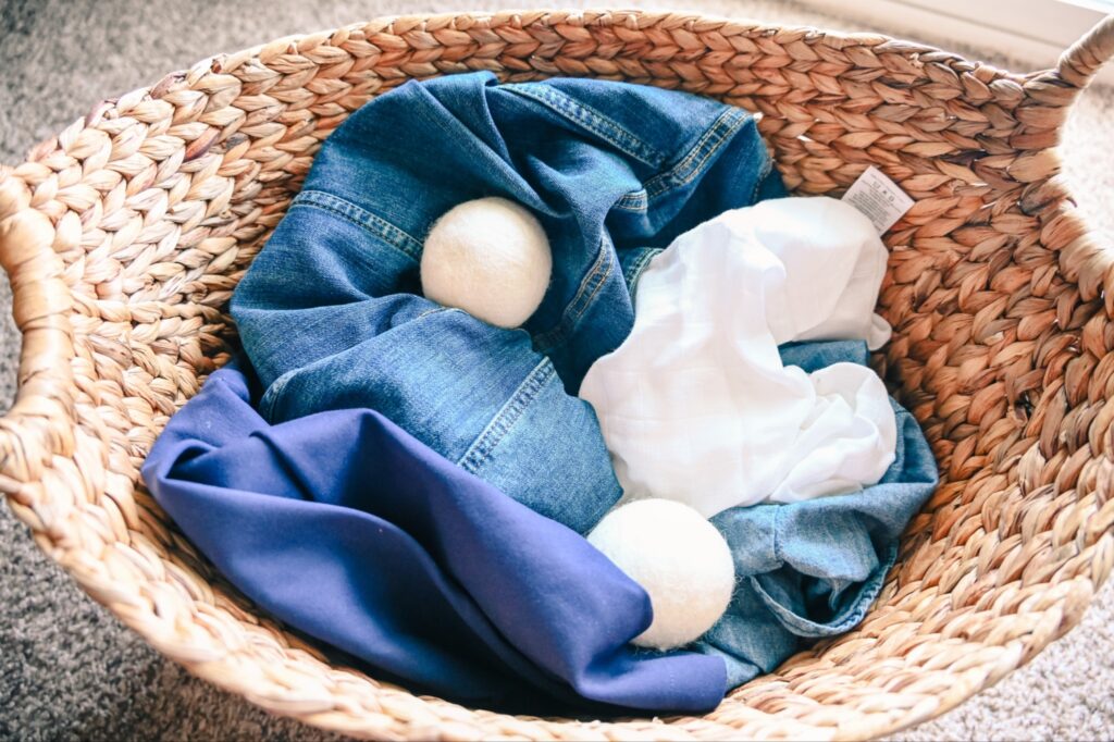 Wool dryer balls mixed with clothes in a laundry basket