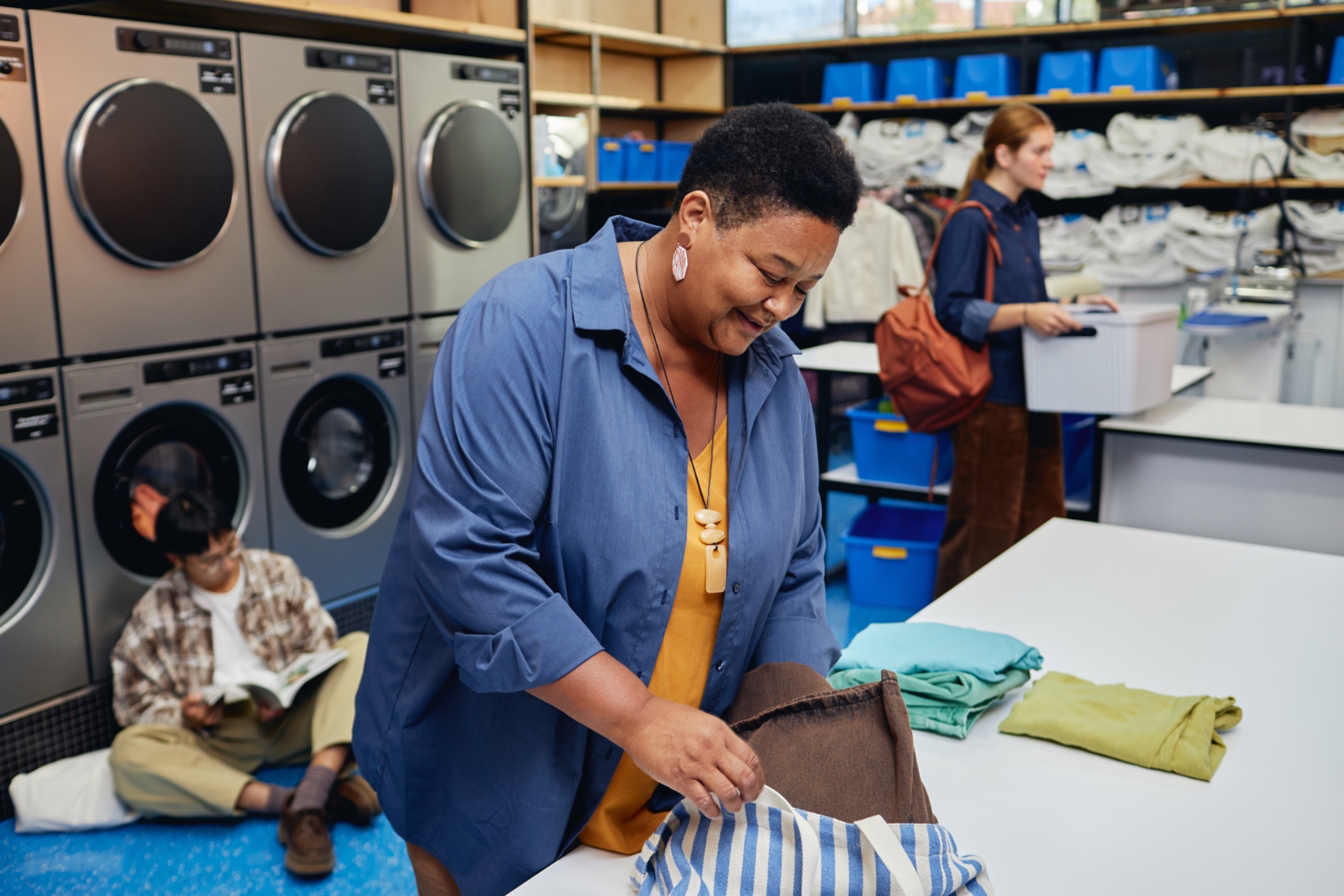 People folding clothes in a laundromat