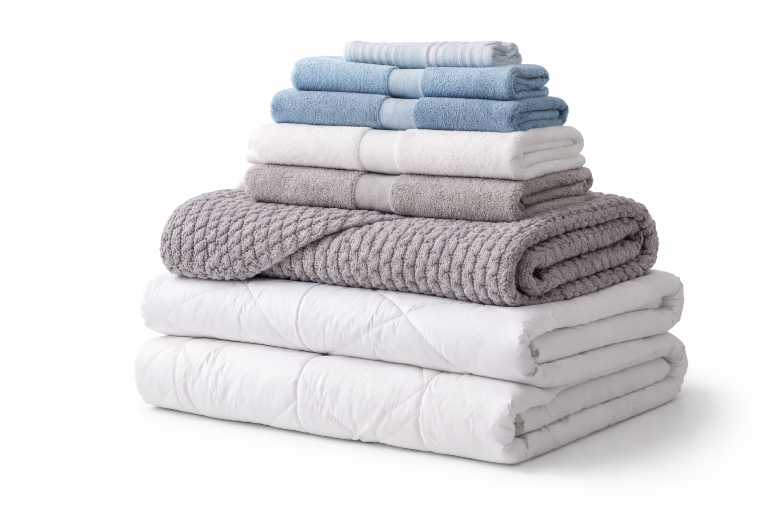 Stacked towels and blankets in neutral colors