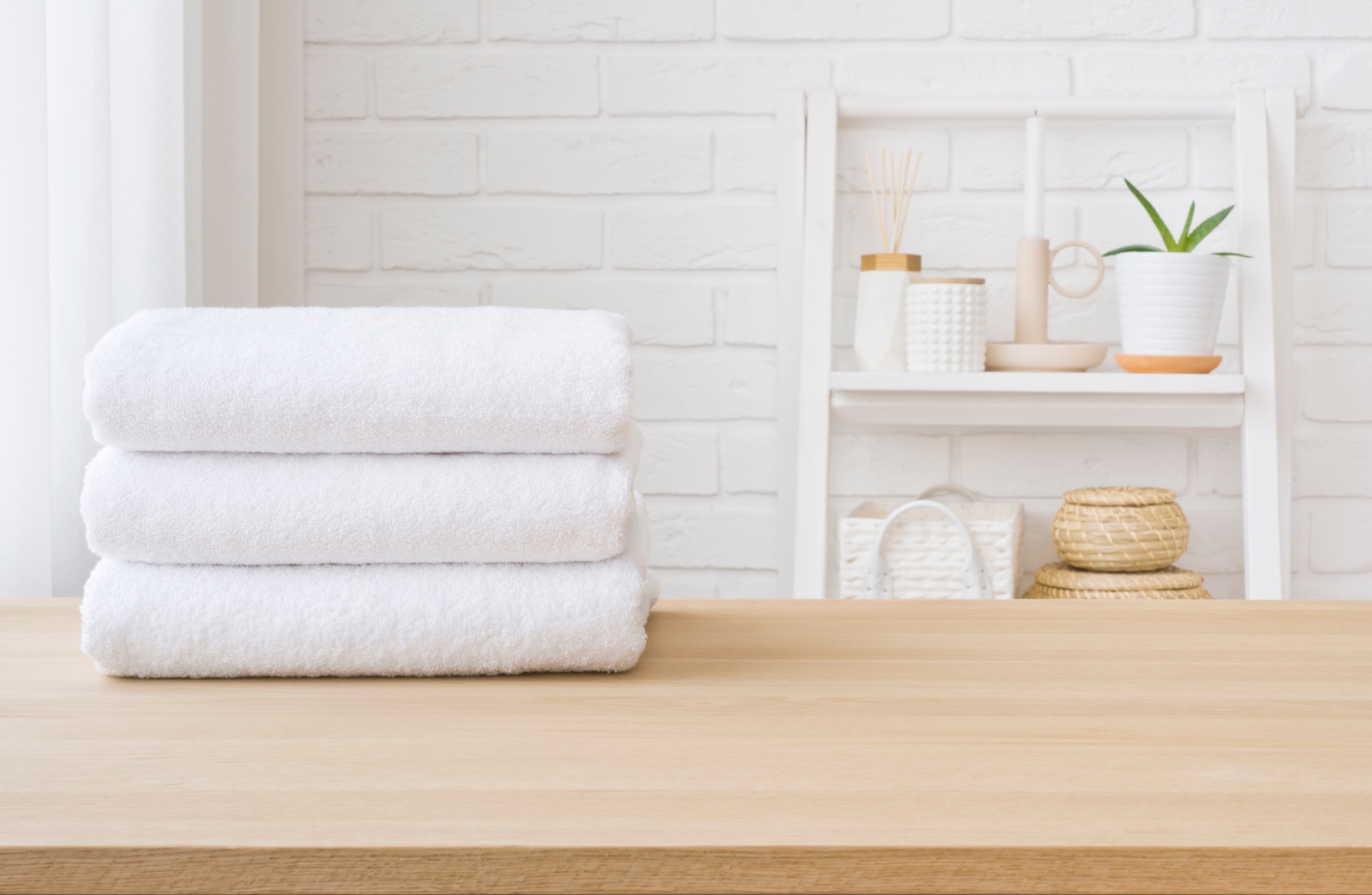 Three white towels on wooden table