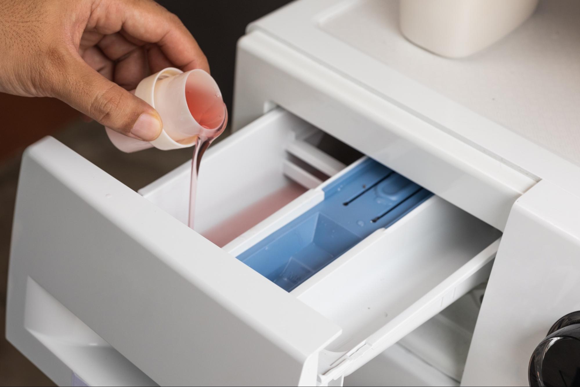 Person adding liquid detergent to washing machine