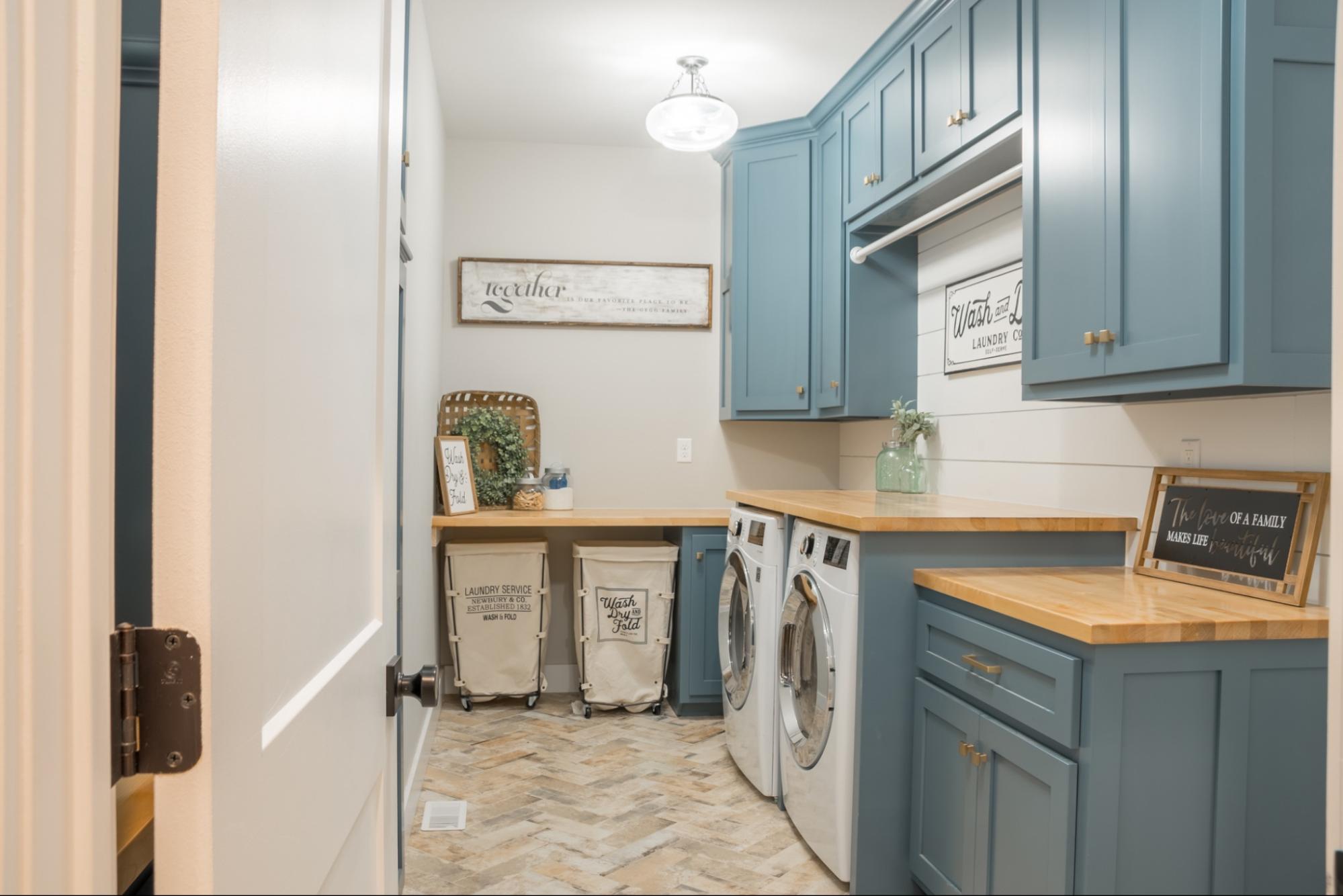 Laundry room with blue cabinets and washer dryer