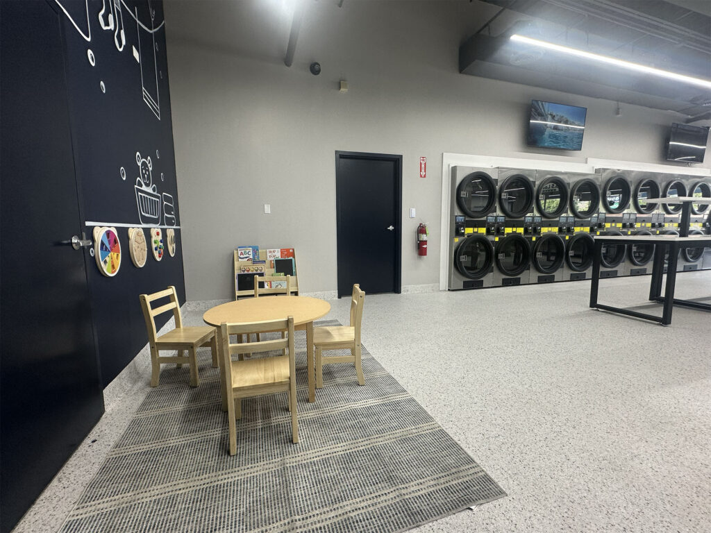 Kids table and books beside the dryers at BrightSpin on Lincoln Avenue